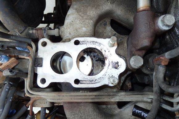 Intake manifold with outline of U-shaped gasket opening and two additional holes in manifold